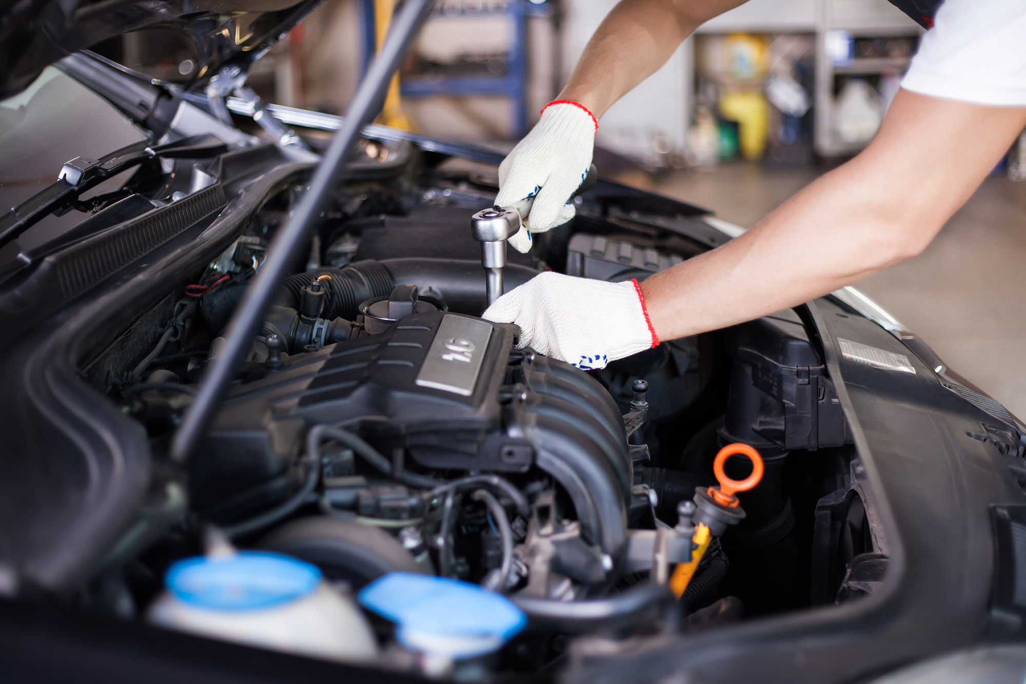 picture of someone fixing a car under the hood