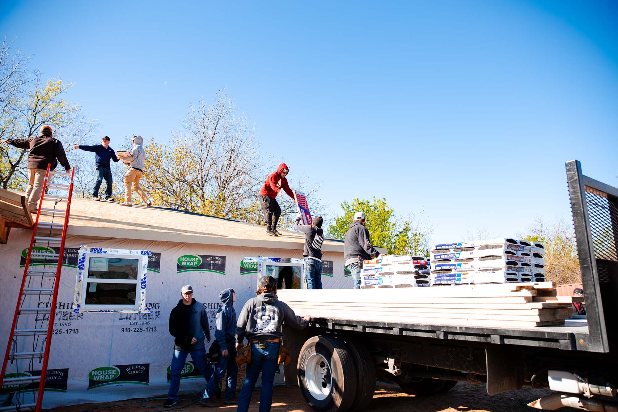 Central Tech Construction students load shingles on top of the house they're building