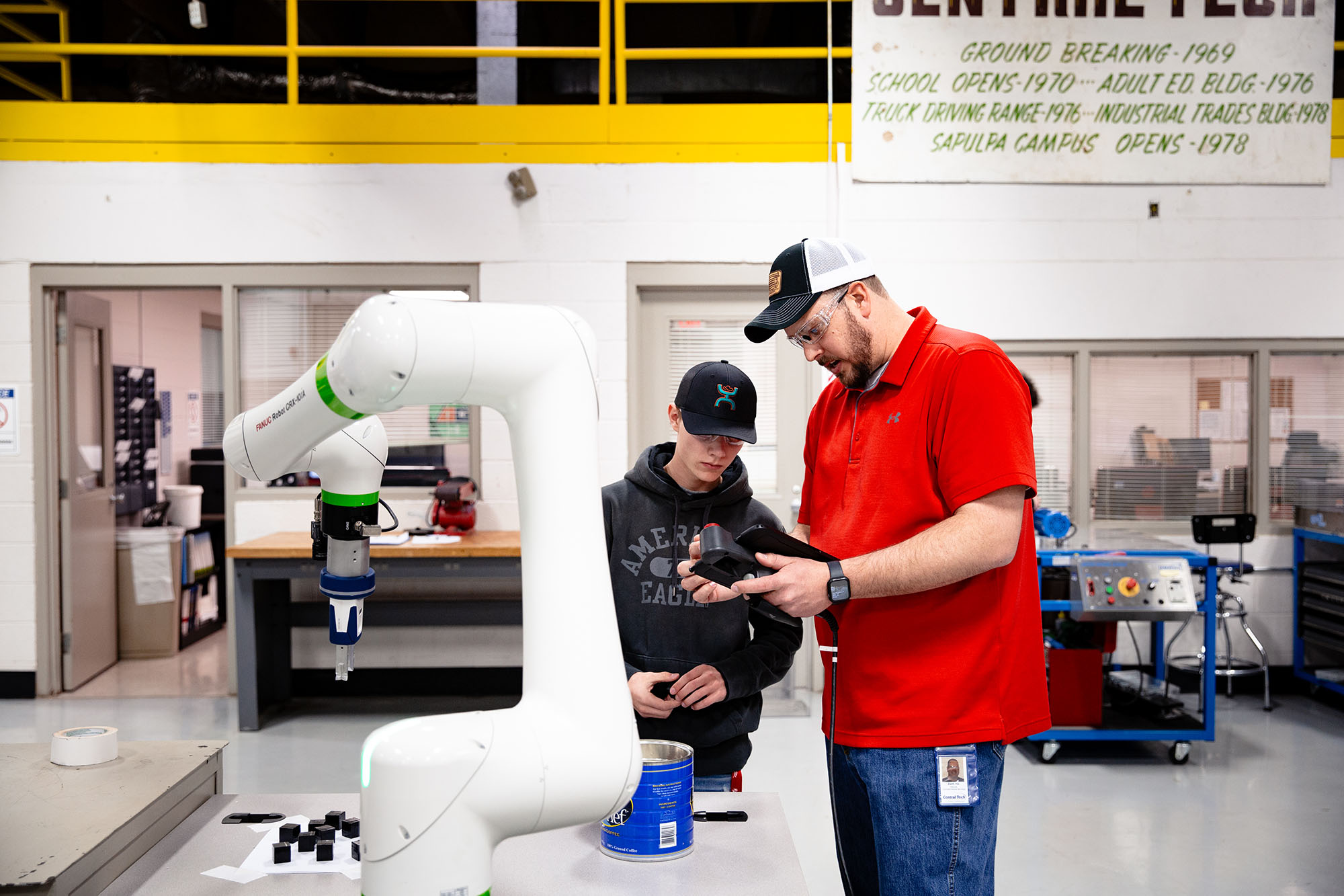 industrial automation teacher helping a student learn how to operate the cobot